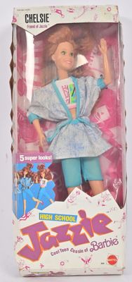 poupée dans la boîte d'une poupée Barbie, vêtue d'un haut bleu et d'un pantalon vert