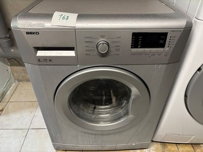 une machine à laver et un sèche-linge posés sur un sol carrelé