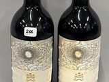 two bottles of red wine sitting next to each other on a table