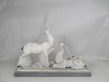 two figurines of animals are sitting on a white surface