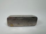 an old silver bar sitting on top of a white surface