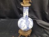 une image représentant un vase bleu et blanc posé sur un socle et muni d'une chaîne