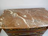 une commode au plateau en marbre, dotée de poignées dorées