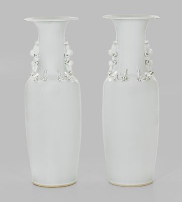 une paire de vases blancs, chacun muni d'une anse perlée