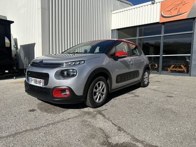 une voiture argentée garée devant un bâtiment dans un parking