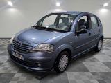 la photo d'une petite voiture bleue garée sur un sol en damier