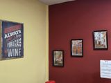 a red chair sitting in front of a red wall with pictures on it