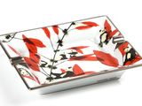 a red and white bowl with black and white flowers on it