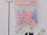 un sachet contenant des ciseaux roses et bleus et une paire de ciseaux noirs et blancs