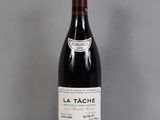a bottle of wine sitting on top of a table next to a glass