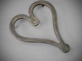 a metal heart shaped object on a white surface