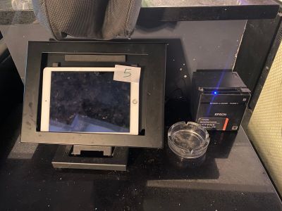 une tablette posée sur un bureau, à côté d'une tasse