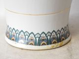 a white pot with blue and yellow designs on it