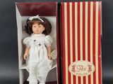 an image of a doll in a box with a red and white striped box