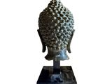 the head of a buddha statue is shown on a stand