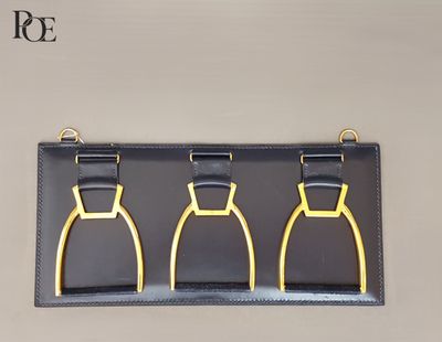 trois étriers noirs et dorés accrochés au mur