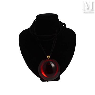 collier avec une boule en verre rouge sur un mannequin noir