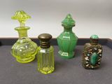 quatre bouteilles en verre de couleurs différentes posées sur un plateau