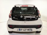 a picture of a small white car parked in a showroom