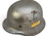 an old steel helmet with a yellow sticker on the side of it