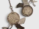 une paire de ciseaux et une pièce de monnaie attachée à une chaîne