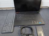 a laptop and headphones on the floor next to a remote