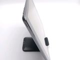 a tablet computer sitting on a stand on a white surface