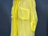 yellow shirt on a mannequin stand against a blue wall