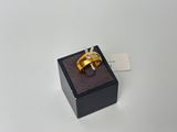 une bague en or dans un écrin noir posé sur une surface blanche