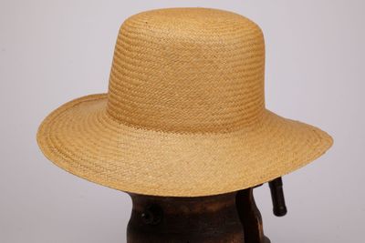 un gros plan d'un chapeau de paille sur une tête de mannequin