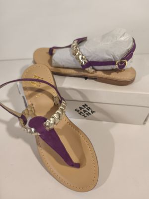 the purple sandals are next to a white box on the table