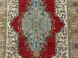 a close up of a red and blue rug with a medallion design