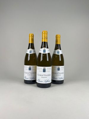 trois bouteilles de vin blanc posées les unes à côté des autres sur une table