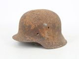 an old rusty helmet with holes on the side of it