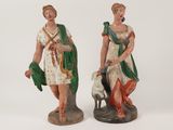 two figurines of a woman and a man with a dog