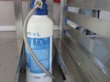 une bouteille d'eau posée sur un plan de travail, à côté d'une étagère en métal