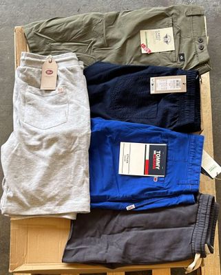 plusieurs paires de pantalons pour homme posées sur une caisse en bois