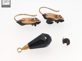 two pairs of gold and black earrings with a black faceted stone