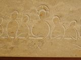 a stone carving of a group of people sitting on a bench
