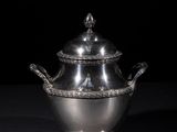 an antique silver plated sugar dish with a lid and handles