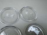 three clear glass dishes with a bird design on them sitting on a table