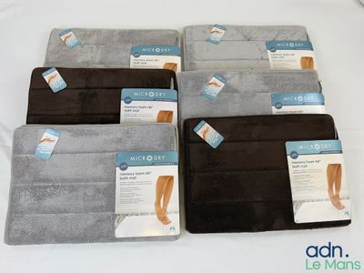 Quatre paires de coussinets pour les pieds sont présentées sur un lit, accompagnées d'étiquettes.