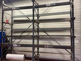 un grand rayonnage sur lequel est posé un rouleau de papier, dans un entrepôt