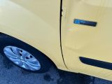 a close up of a yellow car with a blue sticker on it