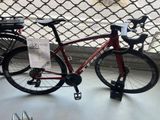 a red bike that is parked next to a fence