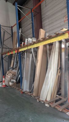 de nombreuses pièces de bois sur une palette dans un entrepôt