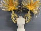 coiffes ornées de plumes jaunes et argentées sur une tête de mannequin