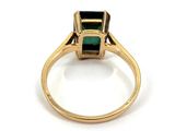 a close up of a gold ring with a green stone