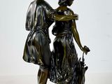 bronze statue of a man and a woman with a dog on a rock