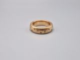 a close up of a gold ring on a white surface